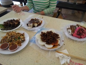 Fried oyster omelette, glutinous rice cakes, fried yam cake, fried carrot (AKA turnip) cake, and jcake, and steamed rice cakes topped with diced savory preserved radish (so good!) at Tiong Bahru Hawker Centre 